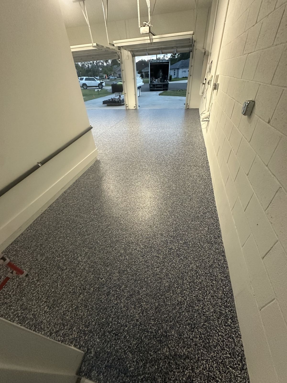 Gray flake garage floor coating looking out the open door