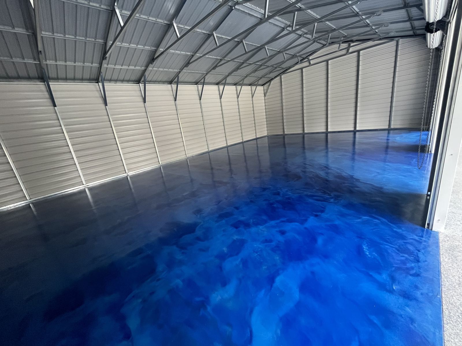 Deep blue metallic floor with flowing marble pattern in a metal building