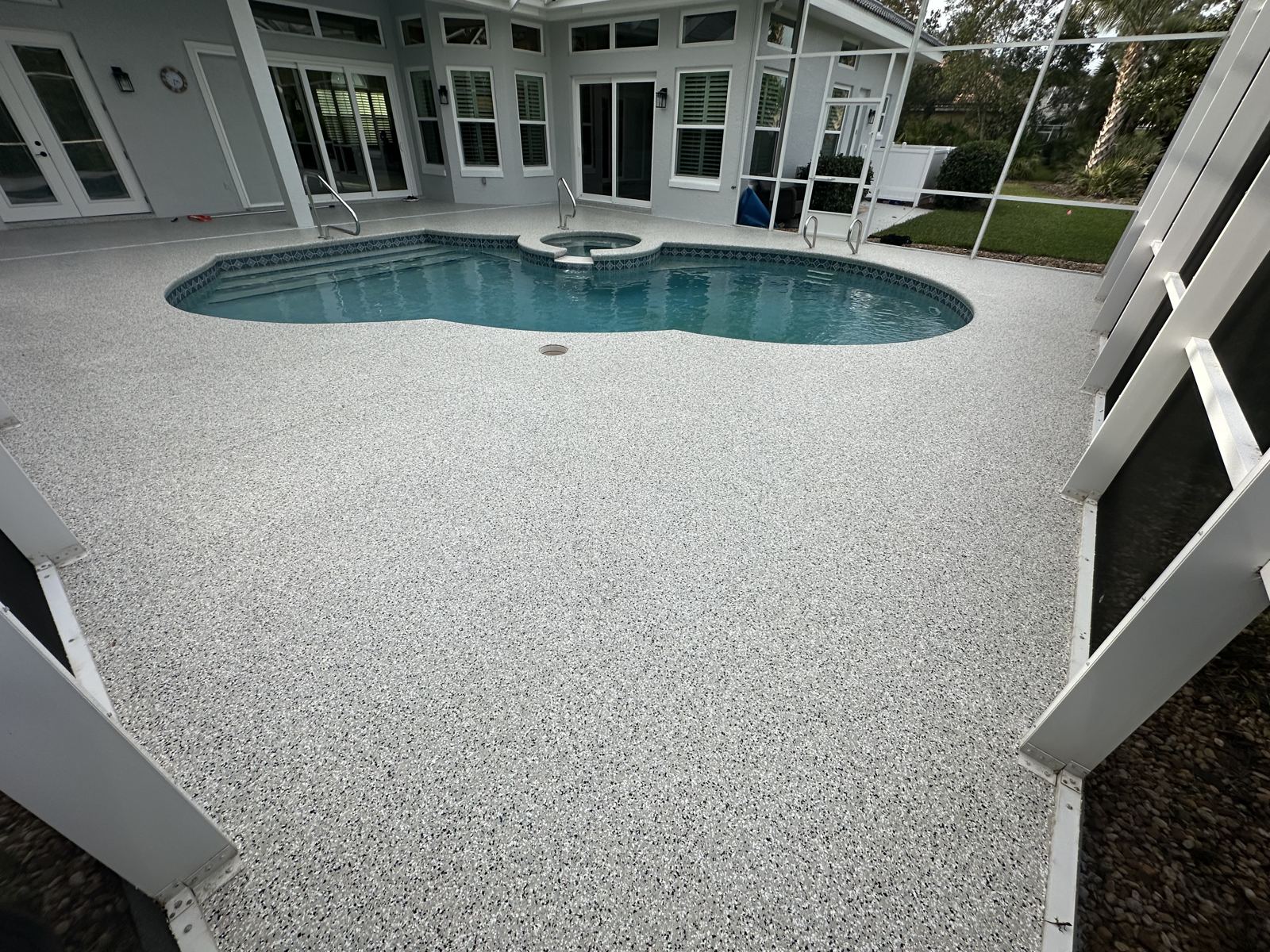 White flake pool deck coating around pool and raised spa